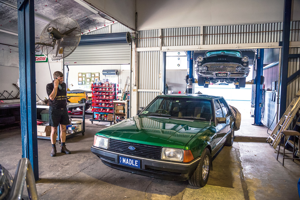 Mechanic Troy Madle answering a customers call in his workshop in Childers, south-east Qld. Photo by Thomas Wielecki. At Work OUTBACK Issue #131.
